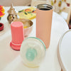 Portable breast milk cooler on table next to breast pump and cooling insert