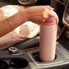 Pink portable breast milk cooler sitting snugly in a car cup holder