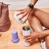 Person pouring contents of breast pump into a purple portable breast milk cooler