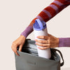 Person putting a Purple portable breast milk cooler into a Willow Pump Anywhere bag