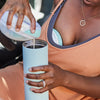 Person in car wearing a portable breast pump pouring her milk into a portable cooler